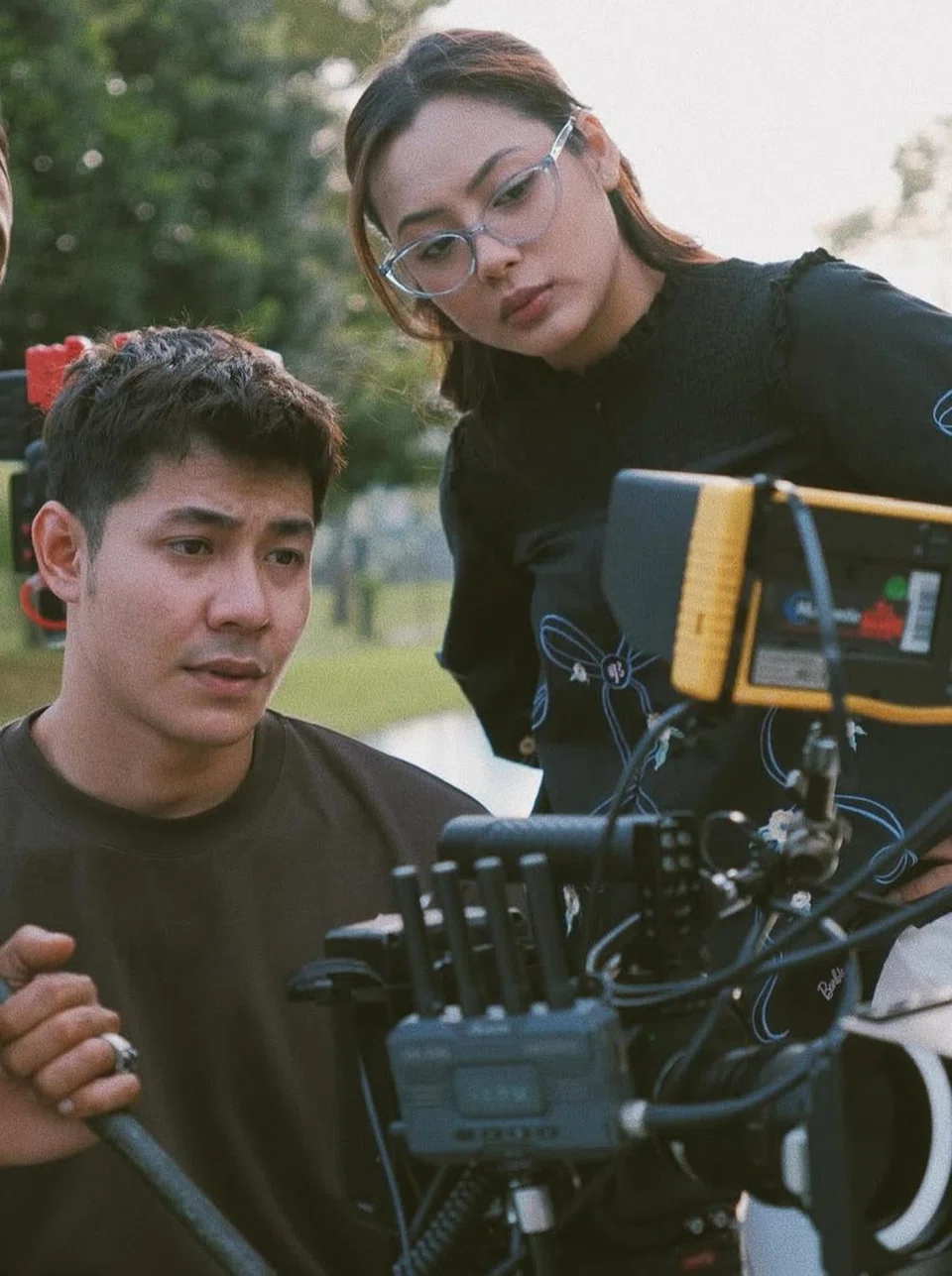 Pelakon Malaysia, Meerqeen (kiri), melihat kembali lakonannya menerusi skrin jurukamera bersama pelakon baru, Ezzanie Jasny, semasa di set penggambaran drama ‘Uncle Bos Mama’. 