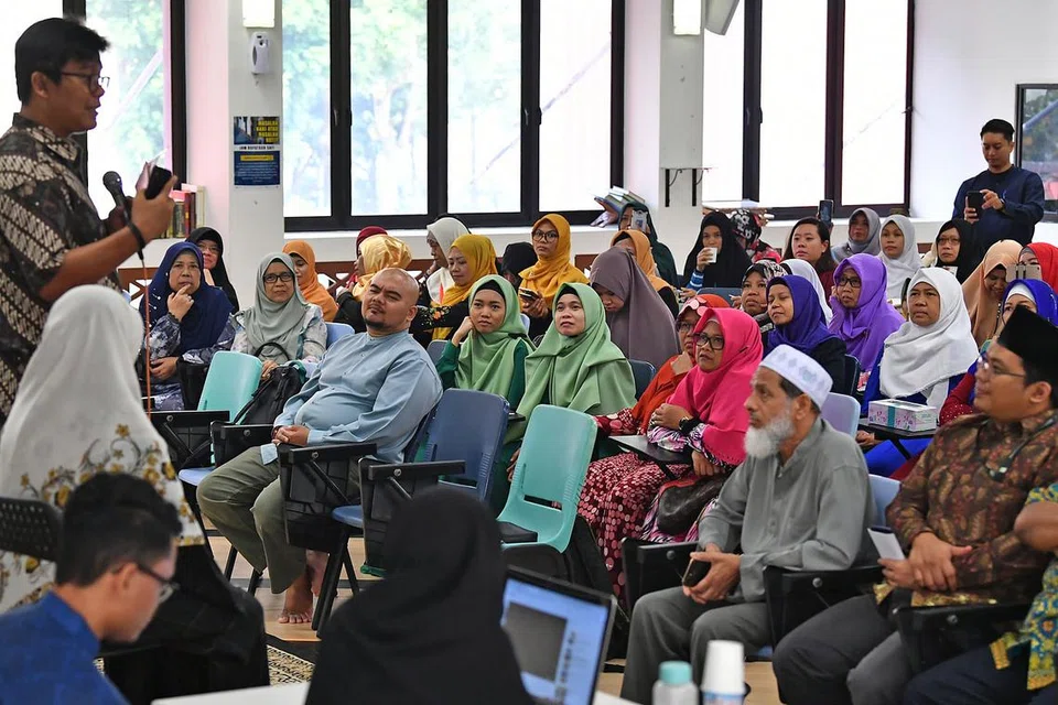 BERWASPADA DENGAN DUNIA DALAM TALIAN: Panelis, termasuk tiga kaunselor RRG dan Dr Noor Huda (kiri, berdiri), di sesi pendekatan bersama pekerja domestik asing Indonesia di Masjid Kampung Siglap semalam. Mereka memberi nasihat agar individu berhati-hati apabila berkenalan dengan orang dalam talian dan berusaha mengesahkan maklumat dengan sumber yang relevan dan boleh dipercayai jika terbaca sesuatu yang mencurigakan. - Foto BH oleh LIM YAOHUI