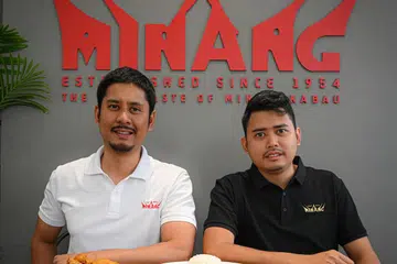 HASILKAN BERSAMA: Encik Muhamad Hazmi (kiri) bersama adiknya, Encik Muhamad Nazri, dan seorang lagi adik, Encik Muhamad Ariff (tiada dalam gambar) menyediakan menu yang sesuai bagi penumpang kelas pertama dan bisnes SIA.