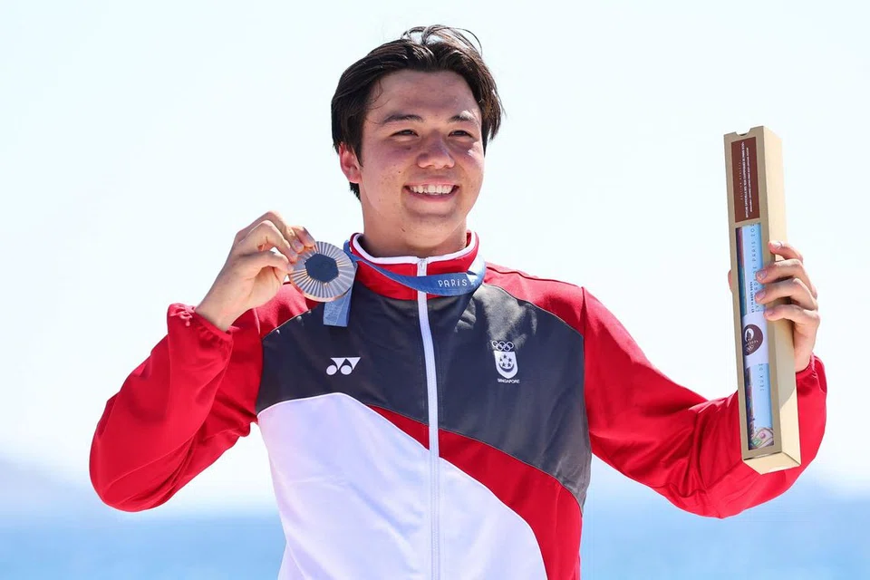 Peserta luncur lelayang Singapura,  Maximilian Maeder, menunjukkan pingat gangsa yang dimenanginya dalam perlumbaan di Marseille Marina di Marseille, Paris, pada 9 Ogos 2024.