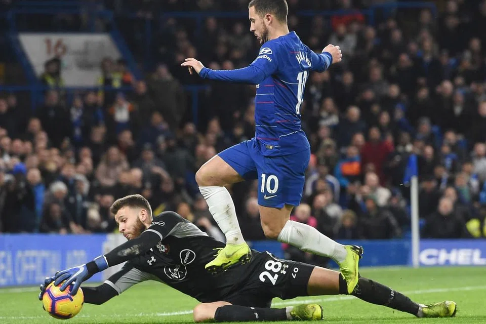 PRESTASI BAIK: Meskipun membuat penampilan sulungnya di EPL, penjaga gawang Southampton, Angus Gunn berjaya menunjukkan persembahan yang memberangsangkan dengan membendung percubaan Hazard (kanan) sebelum berjaya menyelamatkan gawangnya daripada dibolosi. - Foto EPA-EFE