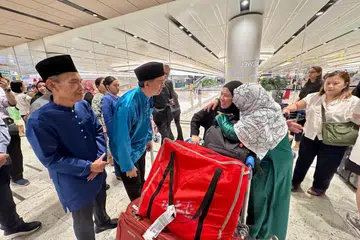 Pemangku Menteri Bertanggungjawab bagi Ehwal Masyarakat Islam, Profesor Madya Dr Muhammad Faishal Ibrahim (dua dari kiri), menyambut kepulangan 15 pelajar Singapura di Jordan yang terkandas pada 25 Jun di Lapangan Terbang Changi Terminal 1.