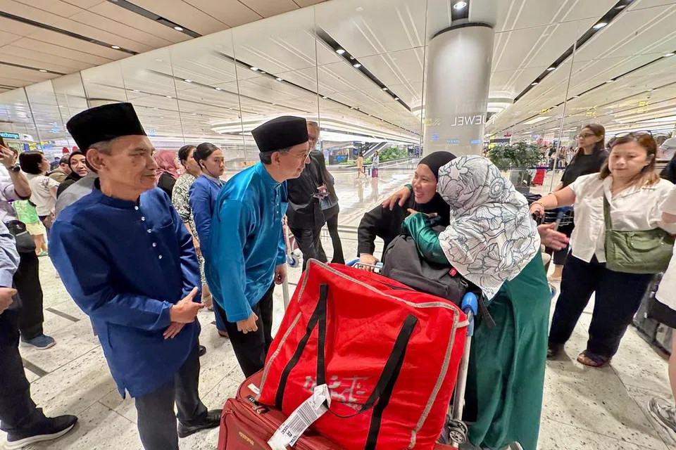 Pemangku Menteri Bertanggungjawab bagi Ehwal Masyarakat Islam, Profesor Madya Dr Muhammad Faishal Ibrahim (dua dari kiri), menyambut kepulangan 15 pelajar Singapura di Jordan yang terkandas pada 25 Jun di Lapangan Terbang Changi Terminal 1.