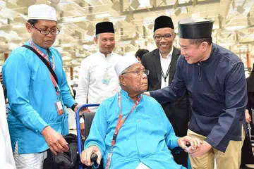 HANTAR JEMAAH: Setiausaha Parlimen Kanan (Ehwal Dalam Negeri merangkap Kesihatan), Encik Amrin Amin (kanan), meluangkan masa berada di Terminal 3 bagi menghantar jemaah Singapura berangkat ke tanah Suci pada Sabtu lalu. Turut hadir ialah Timbalan Ketua Eksekutif Muis Dr Albakri Ahmad (dua dari kanan). - Foto MUIS