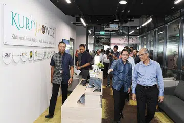 PUSAT SEHENTI: (Depan, dari kiri) Pengurus Besar WGS, Encik Mulyadi Ahmad membawa Dr Maliki dan Encik Masagos meninjau antara kemudahan di KURNIA@WGS bersama tetamu lain. - Foto-foto BH oleh KHALID BABA