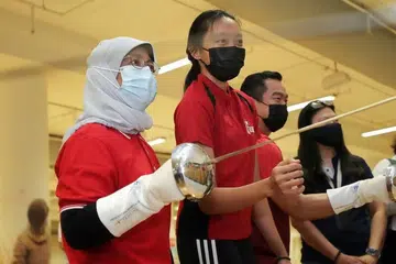 Presiden Halimah Yacob (paling kiri) bersama pelawan pedang Singapura Kiria Tikanah Abdul Rahman (dua dari kiri) di OCBC Arena pada 1 Julai. - Fail ST 