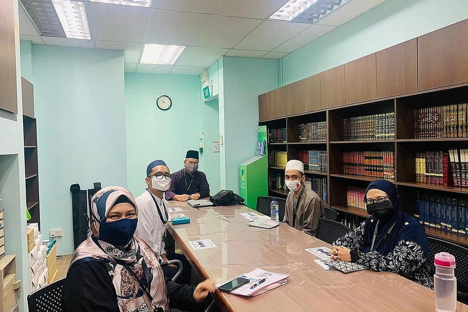 PERLU PENINGKATAN: Masjid Ar-Raudhah di Bukit Batok ini memerlukan projek baik pulih bagi memenuhi keperluan penduduk yang bertambah di samping semakin ramainya jemaah berusia lanjut. Gambar atas pula menunjukkan beberapa kakitangan membincangkan perancangan mengutip dana dan program masjid. - Foto fail