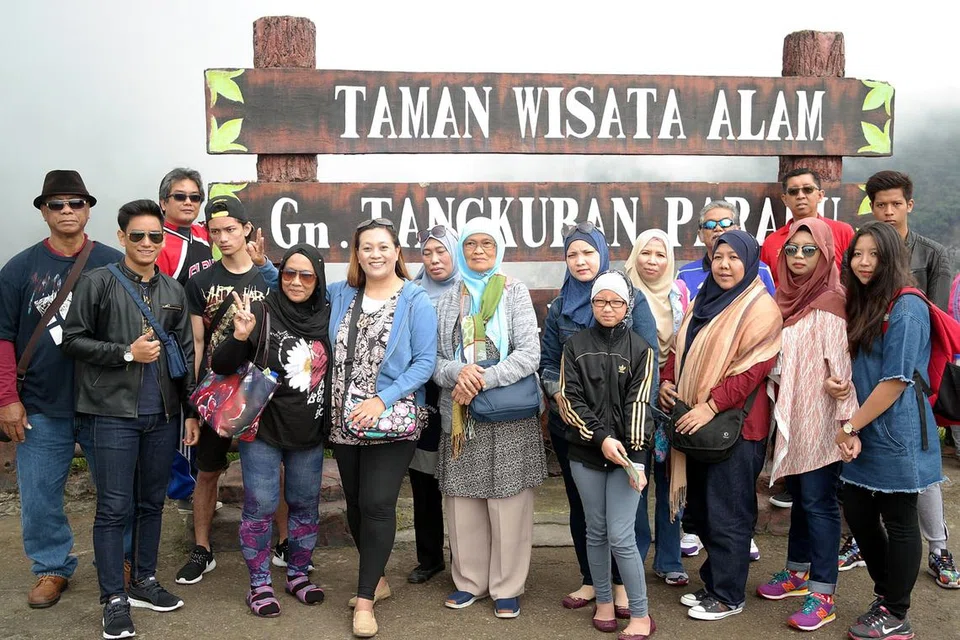 WISATA PENUH KENANGAN: Penulis (belakang, berdiri kedua dari kanan) dan ahli keluarga, sanak-saudara serta sahabat handainya ketika berada di puncak Gunung Tangkuban Perahu di Bandung. - Foto JOHARI SELAMAT