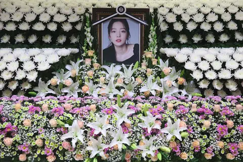 PENGHORMATAN TERAKHIR: Pelbagai jenis bunga mengelilingi gambar penyanyi dan pelakon popular dari Korea Selatan, Goo Hara, sebagai penghormatan terakhir kepada bintang K-Pop itu yang meninggal dunia Ahad lalu. - Foto AFP