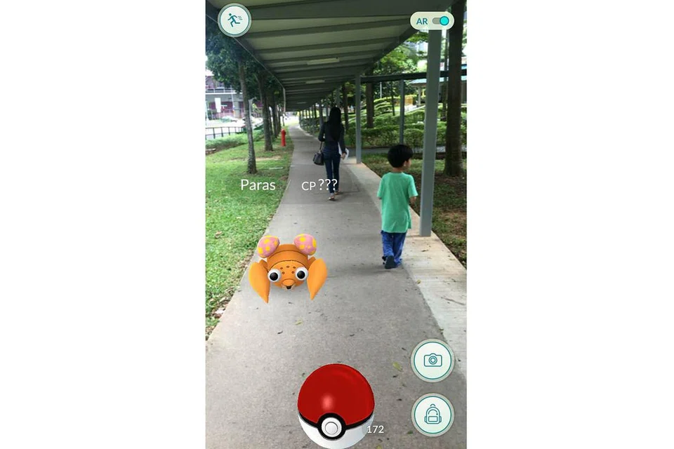 KEGILAAN RAMAI: Inilah wajah permainan Pokemon Go. Kelihatan watak Pokemon bernama Paras 'timbul' di laluan pejalan kaki di sini. - Foto fail
