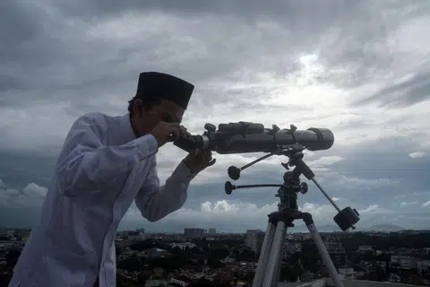 Seorang anggota jemaah Muslim menggunakan teleskop untuk melihat kemunculan anak bulan yang menandakan permulaan bulan suci Ramadan di Bandung, Jawa Barat pada 17 Februari 2026. 