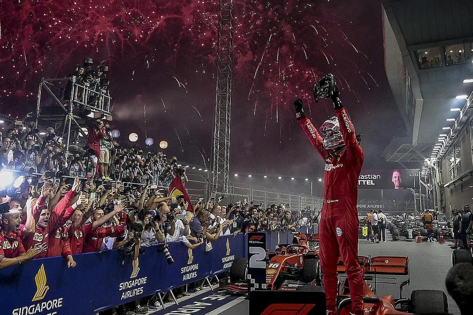 JUARA: Vettel meraikan kejuaraan Formula Satu Grand Prix Singapura di hadapan pasukan Ferrari selepasi melepasi garisan penamat di Litar Marina Bay kelmarin. - Foto BH oleh EPA-EFE