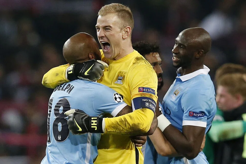 GEMBIRA SEKALI: Penjaga gawang Manchester City, Joe Hart (berjersi kuning), meraikan kejayaan bersejarah pasukan itu dengan Fabian Delph. - Foto REUTERS