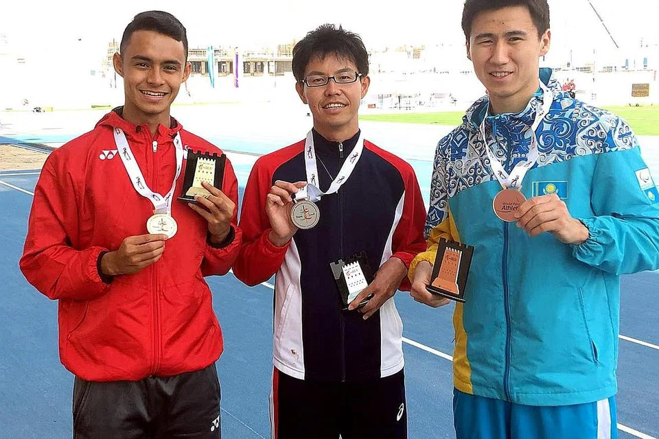 SYABAS CEMERLANG: Suhairi Suhani (kiri) menunjukkan pingat emas Kejohanan Para-Atletik Dunia yang berlangsung di Dubai semasa bergambar dengan dua pesaing utamanya - pemenang perak, Nozomu Detohata (tengah) dan pemenang gangsa Amanat Kalkayev. - Foto MUHAMAD HOSNI MUHAMAD.