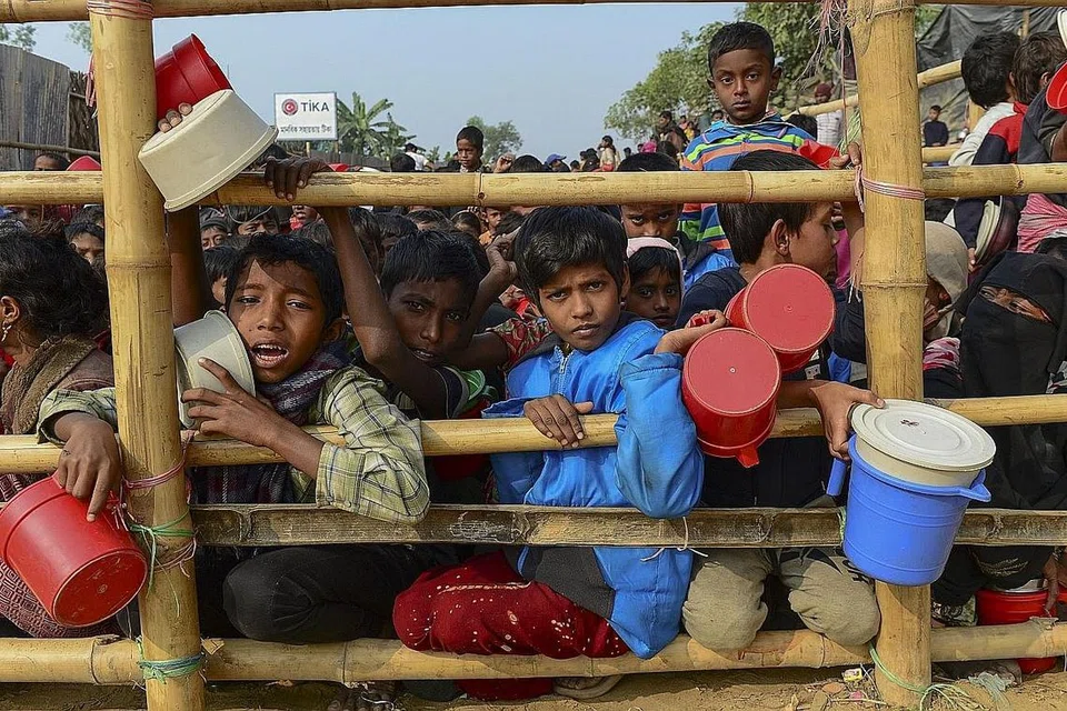 NASIB MELARAT: Foto fail yang dipetik awal tahun ini menunjukkan kanak-kanak pelarian Rohingya beratur untuk mendapatkan bantuan makanan di khemah pelarian Thankhali yang terletak di kawasan Ukhia, Bangladesh. - Foto AFP