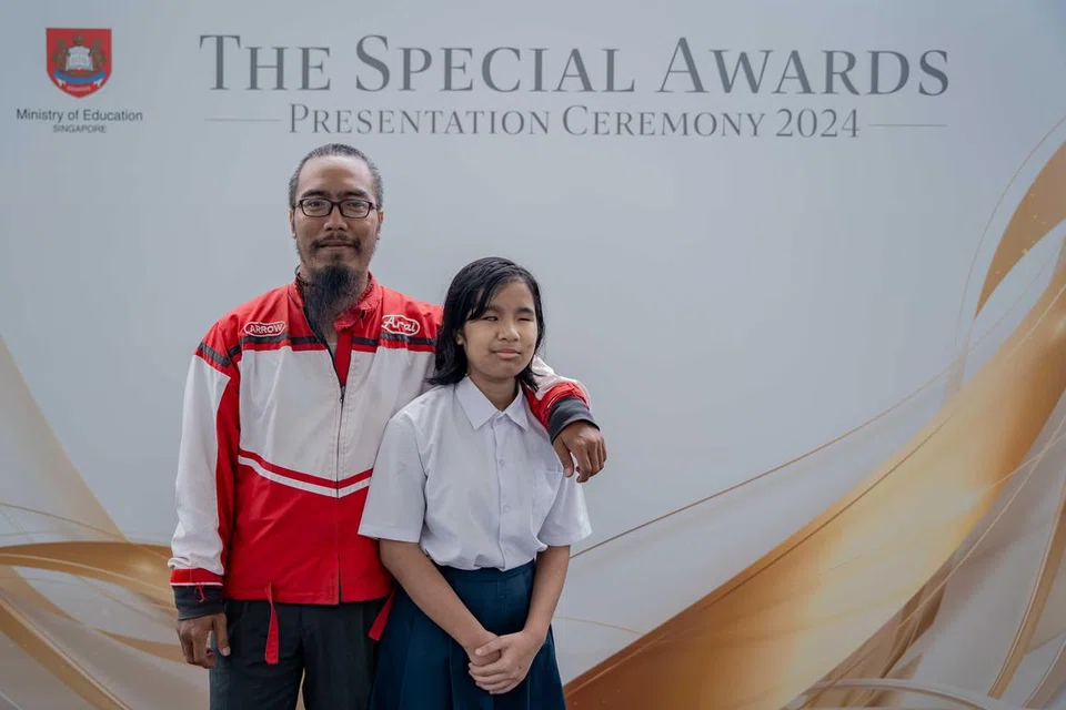 TERIMA ANUGERAH: Afrin Alyssa Mohamed Aidil dan bapa, Mohamed Aidil Nani (kiri), semasa Majlis Anugerah Istimewa di Pusat Kebudayaan Universiti, Universiti Nasional Singapura (NUS), pada 27 Ogos. Afrin Alyssa merupakan antara penerima Anugerah Pelajar Teladan Lee Kuan Yew (LKY-ESA) dalam majlis itu.