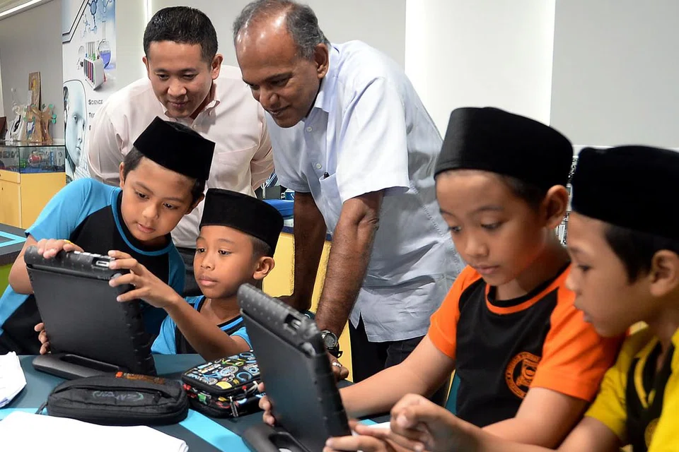 KUNJUNG MADRASAH: Encik Shanmugan (tiga dari kanan) dan Setiausaha Parlimen (Ehwal Dalam Negeri), Encik Amrin Amin (belakang, kiri), turut mengunjungi makmal sains Madrasah Irsyad Zuhri Al-Islamiah semalam. - Foto-foto JOHARI RAHMAT
