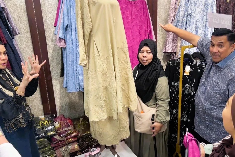 Cik Haminah Ridwan (tengah), bersama Pengerusi Persatuan Usahawan Angsana Johor Bahru, Encik Mohd Kamaruzaman Ismail (kanan), dan isterinya, Cik Norhaini Noordin (kiri), di AKF Boutique by MCL.