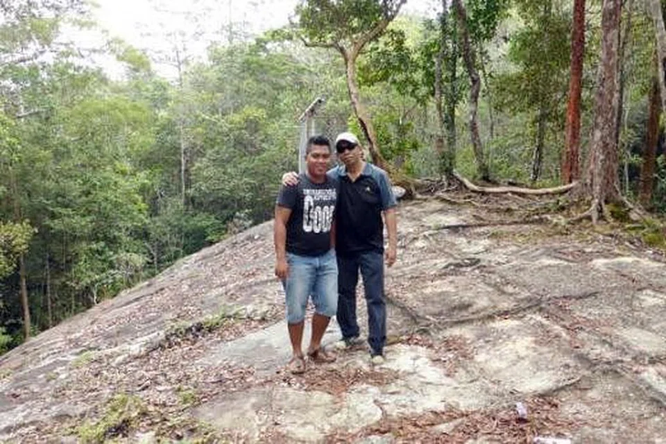 BATU KAPAL: Penulis (kanan) bersama pemandu pelancong, Encik Azmi, di atas bongkah batu yang di panggil 'Batu Kapal' di puncak Gunung Jerai. - Foto-foto ABDUL JALIL MARZUKI