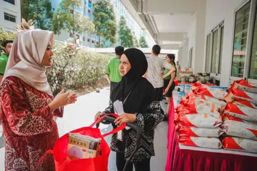 Setiausaha Parlimen Kanan (Kesihatan merangkap Undang-Undang), Cik Rahayu Mahzam (paling kiri), berkongsi maklumat makanan yang lebih sihat bersama penerima habuan, Cik Fatimah Osman, semasa acara pengagihan yang diadakan di Store@Woodlands, di Blok 852 Woodlands Street 83, pada 6 April. 