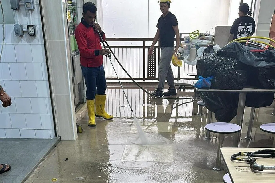 Kontraktor melakukan kerja pembersihan di kawasan pusat makan di Pasar Geylang Serai pada 30 Oktober.