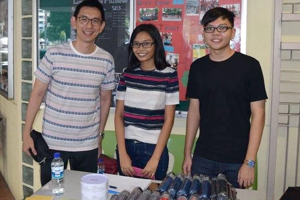 JADI 'USAHAWAN': Cik Nur Amira bergabung tenaga dengan rakan sekolah Po Wei Xiang (kanan) dan gurunya Encik Raymond Chia bagi menjual barangan mereka untuk mengumpul modal. - Foto YMCA