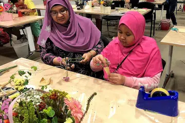 MELUANGKAN MASA BERSAMA: Cik Zurita A Rahim dan anaknya, Nurlyra Delaila Abdullah sama-sama mempelajari cara menggubah bunga di bengkel 'Flower Jamming' pada cuti sekolah yang lalu. - Foto ITE