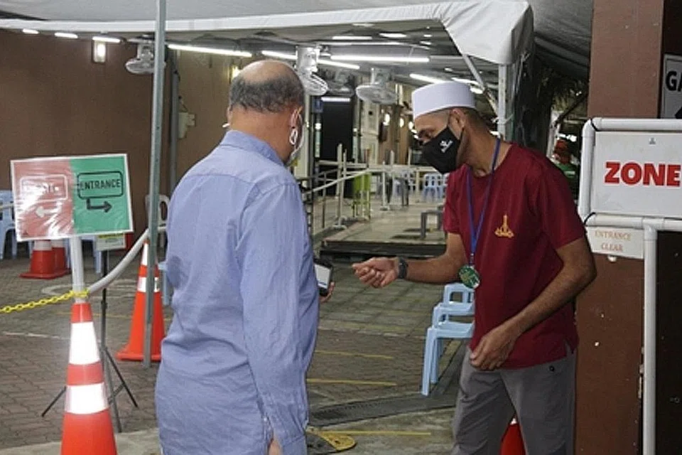 LEGA JEMAAH FAHAM: Sukarelawan masjid, Encik Abdul Basit Abdul Hamid (kanan), lega kerana jemaah sudah mula menerima dan memahami keperluan langkah pengurusan selamat di MAKM. Beliau tetap meluangkan masa menguruskan Safe Entry pada waktu subuh sebelum bergegas ke tempat kerjanya pada siang hari.
