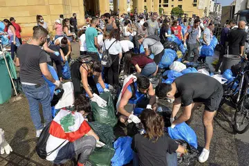 GOTONG-ROYONG: Warga Lebanon membersihkan kawasan di sekitar Dataran Pahlawan di ibu kota negara itu yang berselerak dengan botol air plastik, sampah sarap dan bendera merah putih. - Foto EPA-EFE