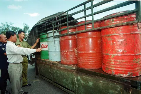 Komander Kawasan Unit Pencegah Penyeludupan (UPP) Chuping,  Penolong Superintenden (ASP) Khamis Hamzah (berbaju cerah) bersama anggota-anggotanya memeriksa tong yang berisi minyak diesel yang dirampas di Kampung Kubang Tiga pada 10 Mei lalu.  Bahan api itu dipercayai akan diseludup ke Thailand. 