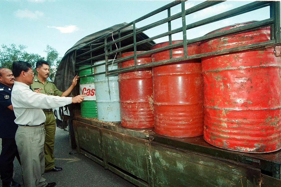 Komander Kawasan Unit Pencegah Penyeludupan (UPP) Chuping,  Penolong Superintenden (ASP) Khamis Hamzah (berbaju cerah) bersama anggota-anggotanya memeriksa tong yang berisi minyak diesel yang dirampas di Kampung Kubang Tiga pada 10 Mei lalu.  Bahan api itu dipercayai akan diseludup ke Thailand. 