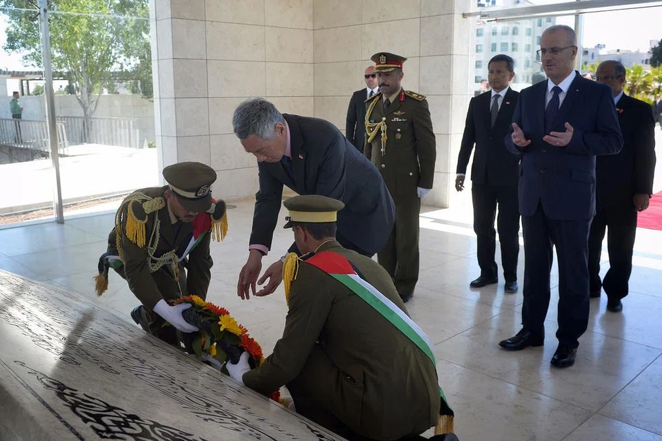 KUNJUNGAN KE RAMALLAH: Encik Lee meletakkan bunga di makam Yasser Arafat. Beliau turut diiringi Perdana Menteri Palestin, Encik Rami Hamdallah (belakang, sedang berdoa) , Encik Masagos Zulkifli (belakang, kanan) dan Dr Vivian Balakrishnan (kanan Encik Masagos). - Foto THE STRAITS TIMES