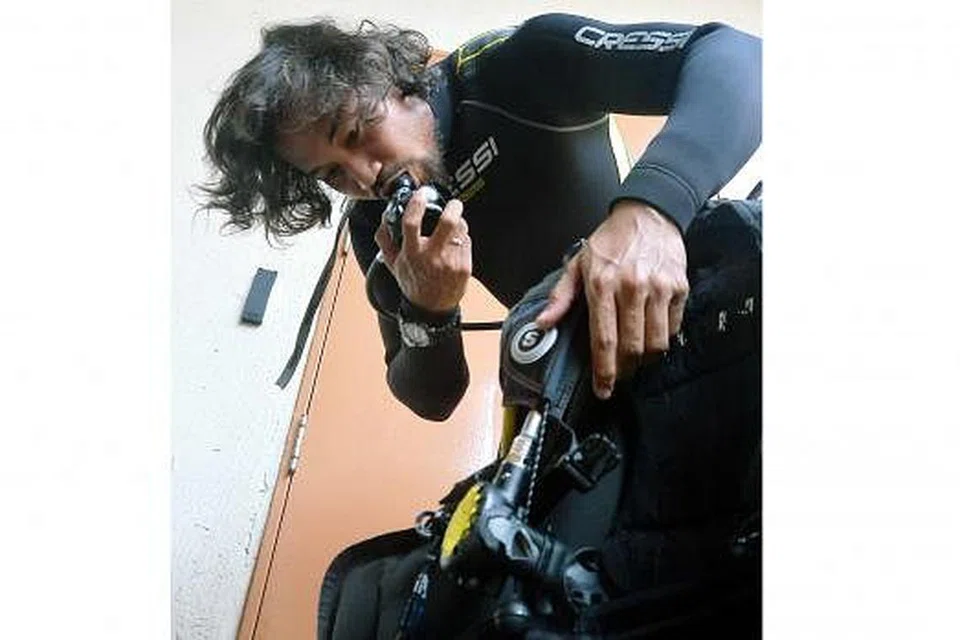 PERIKSA PERALATAN: Encik Salleh memeriksa tangki oksigen sebelum menyelam.