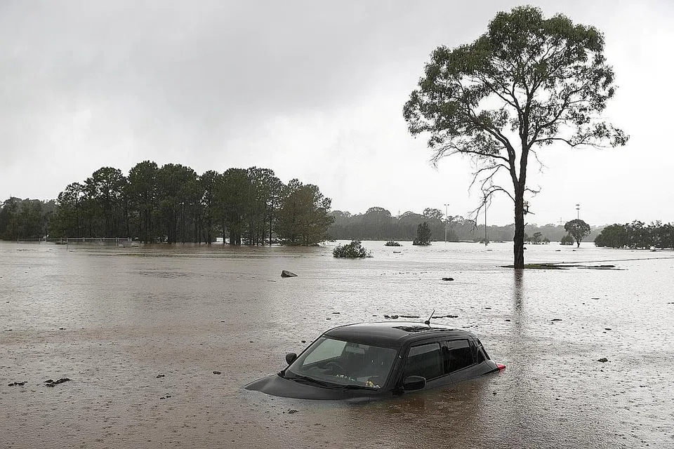 CUACA TIDAK MENENTU: Sebuah kereta yang separuh tenggelam ditinggalkan dalam air banjir di New South Wales, Sydney di Australia pada 22 Mac 2021. - Foto REUTERS