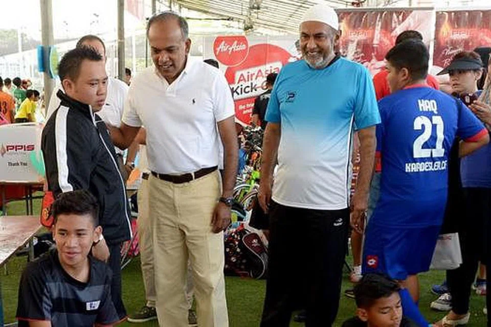 KEJOHANAN MENYATUKAN SEMUA LAPISAN MASYARAKAT: Haji Allaudin Mohamed (bersongkok) bersama Menteri Ehwal Luar merangkap Undang-Undang, Encik K. Shanmugam, berjumpa dengan pasukan-pasukan sebelum bermulanya perlawanan futsal. - Foto TUKIMAN WARJI