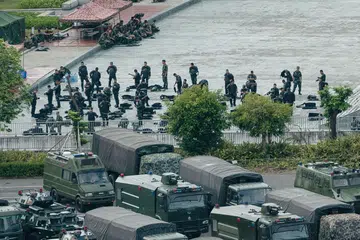 LATIHAN TENTERA: Anggota tentera China berkumpul dekat trak-trak dan kenderaan tentera lain di stadium Shenzhen Bay, Shenzhen yang bersempadankan Hongkong. Akhbar yang rapat dengan China memberi amaran China mempunyai pilihan untuk "campur tangan secara paksa" bagi menamatkan bantahan ganas di Hongkong. - Foto AFP
