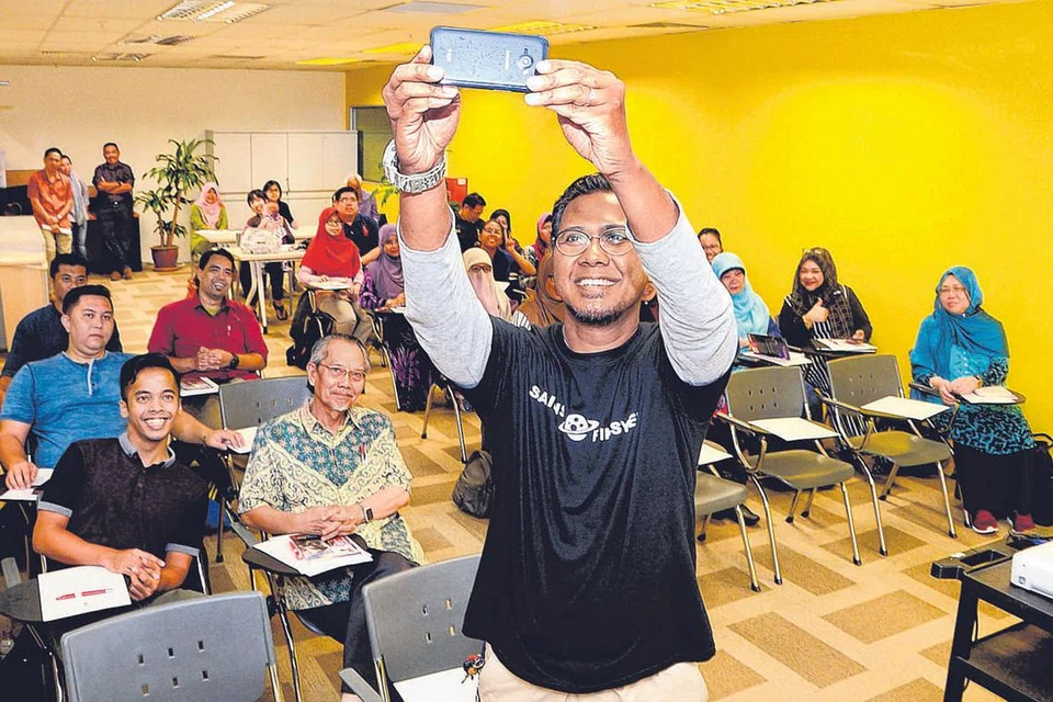 BENGKEL MENULIS: Encik Hassan (paling depan) mengambil gambar sesi bersama peserta bengkel, selain berkongsi beberapa tip berguna dalam menulis cerpen bersama mereka. - Foto JOHARI RAHMAT