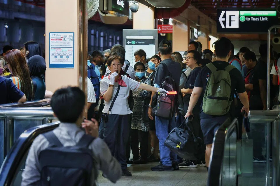 Seorang pegawai SMRT kelihatan sedang membantu penumpang di stesen MRT Jurong East pada 26 September, 6.40 pagi.