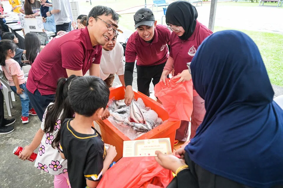  Encik Muhammad Mizzuan Maslan (bertopi), pemilik kedai ikan Chiongster.co di pasar Pelabuhan Perikanan Jurong mengagihkan ikan di Ramadan on Wheels anjuran 4PM. Ini merupakan kali pertama beliau menjadi relawan bersama 4PM.