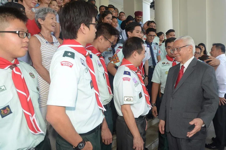 HARGAI SUMBANGAN SUKARELAWAN: Presiden Tony Tan (kanan) beramah mesra bersama sukarelawan daripada Persatuan Pengakap Singapura (SSA) dalam satu majlis jamuan teh di Istana semalam. - Foto THE STRAITS TIMES