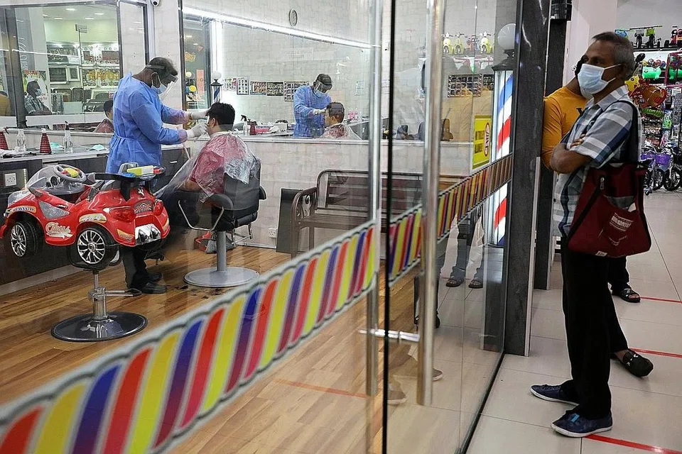 DIBUKA SEMULA JUGA: Pelanggan beratur menunggu giliran mereka di luar sebuah kedai gunting rambut di Kuala Lumpur semalam, selepas ia dibuka semula setelah sekatan ditarik balik mulai semalam. - Foto REUTERS