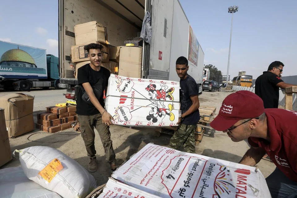 SIAP HANTAR BANTUAN: Sukarelawan Mesir mengendalikan bantuan kemanusiaan untuk rakyat Palestin di Semenanjung Gaza, di persimpangan sempadan Rafah, Mesir. 