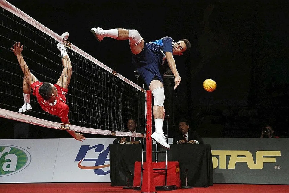 'SEPAKAN MAUT': Pemain nasional, Muhammad Hafiz Nor Izam Ja'afar (jersi merah), melakukan sepakan akrobatik semasa pertemuan dengan Malaysia dalam satu kejohanan Super Series pada 2014. - Foto fail