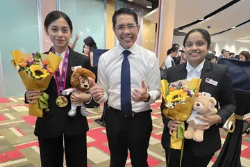 Menteri di Pejabat Perdana Menteri, Dr Mohamad Maliki Osman (tengah), menegaskan kepentingan warga Singapura sentiasa meningkat kemahiran untuk memastikan daya saingan dalam zaman ekonomi yang mudah dilanda gangguan. Bersamanya, peserta Kesihatan dan Penjagaan Sosial dari Institut Pendidikan Teknikal (ITE), Aqilah Tarishah Mohamad Fadil, 19 tahun (kiri), dan Savitha Vikkiraman, 18 tahun. 