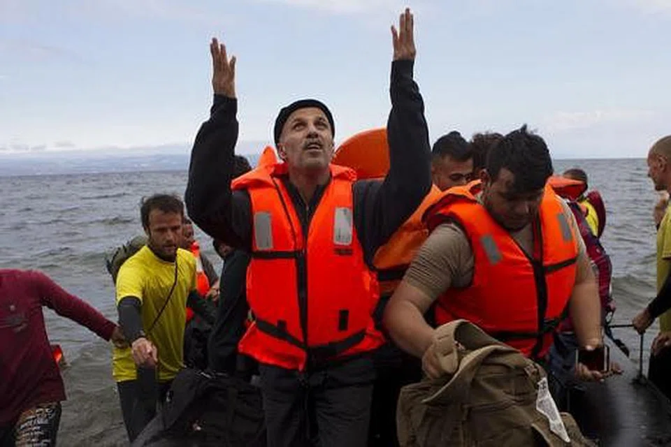 SYUKUR: Seorang pelarian Syria berdoa sebaik saja tiba di Pulau Lesbos di Greece kelmarin selepas menyeberang Laut Aegean dari pantai Turkey. - Foto REUTERS
