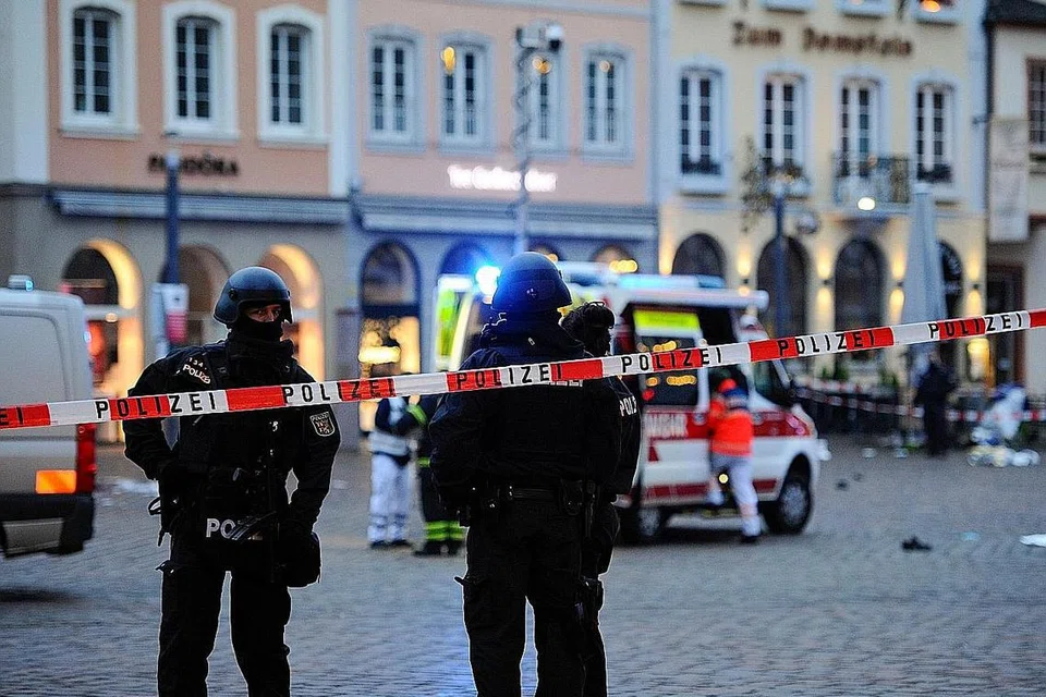MALANG TAK BERBAU: Anggota polis penyiasat dan paramedik menghulur bantuan kecemasan dan melakukan siasatan susulan kemalangan di Trier, Jerman, yang mengorbankan lima orang kelmarin. - Foto AFP
