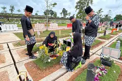 Cik Norris Sanat (dua dari kiri) ziarahi kubur anaknya, Allahyarham Mohd Shahfiq Irman, bersama keluarga di pagi Syawal pertama selepas menunaikan solat Hari Raya Aidilfitri pada 10 April. (Gambar sisipan) Allahyarham Shahfiq.