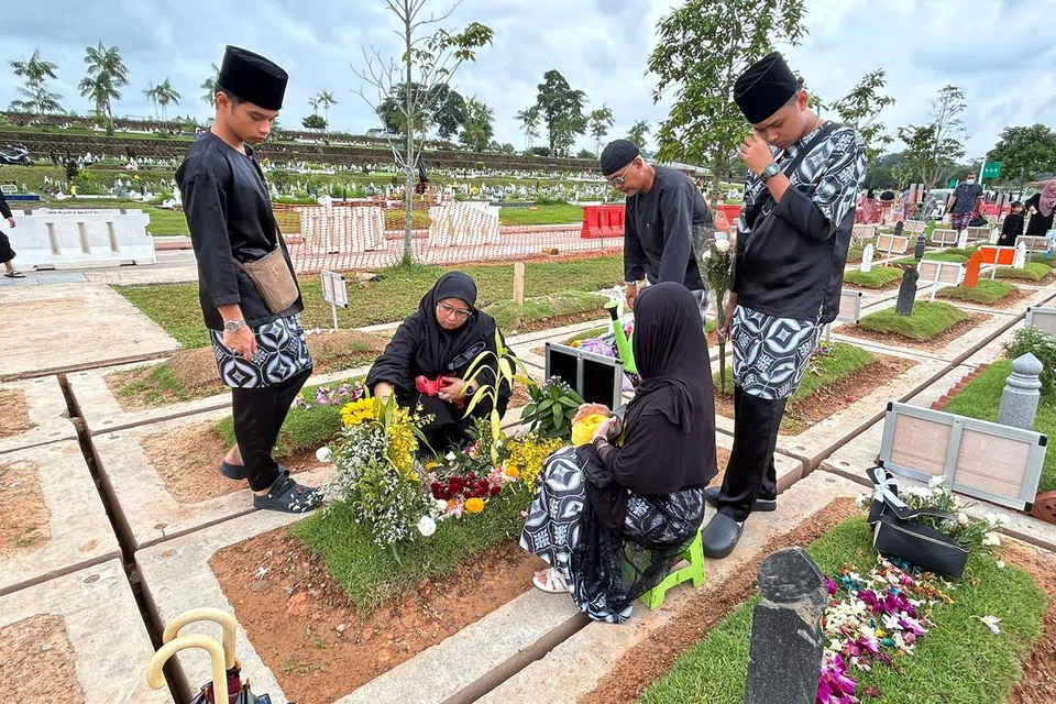 Cik Norris Sanat (dua dari kiri) ziarahi kubur anaknya, Allahyarham Mohd Shahfiq Irman, bersama keluarga di pagi Syawal pertama selepas menunaikan solat Hari Raya Aidilfitri pada 10 April. (Gambar sisipan) Allahyarham Shahfiq.