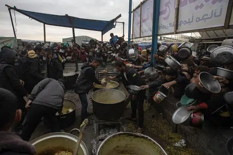 Kanak-kanak dan penduduk Palestin di Khan Younis, di selatan Gaza Selatan, mengharapkan makanan dari dapur amal pada 29 November. Lebih 1.8 juta penduduk Gaza kini berdepan kekurangan makanan kritikal dengan 133,000 daripadanya mengalami tahap kebuluran.