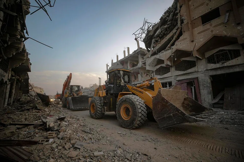 Petugas Palang Merah membantu pejuang Briged Al-Qassam, sayap ketenteraan gerakan Hamas, mencari mayat tebusan Israel di kejiranan Al-Shejaeiya, timur Bandar Gaza, Semenanjung Gaza, pada 5 November 2025.